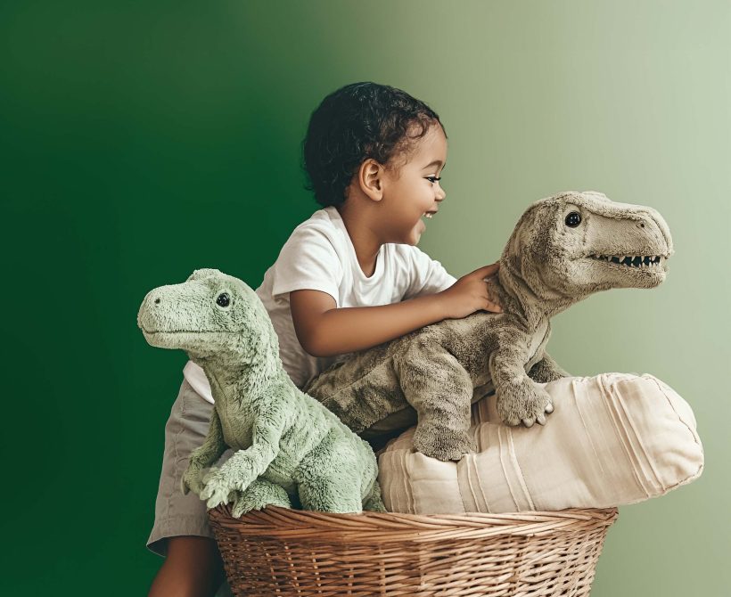Enfant jouant calmement avec des dinosaures en peluche, symbole de routines rassurantes favorisant la sécurité affective et l’autonomie.